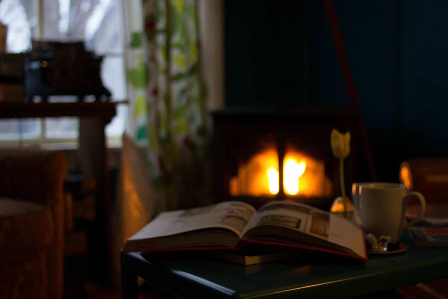 Reading a book by the fireplace in winter